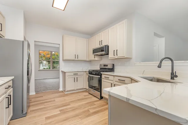 a kitchen with white cabinets and appliances
