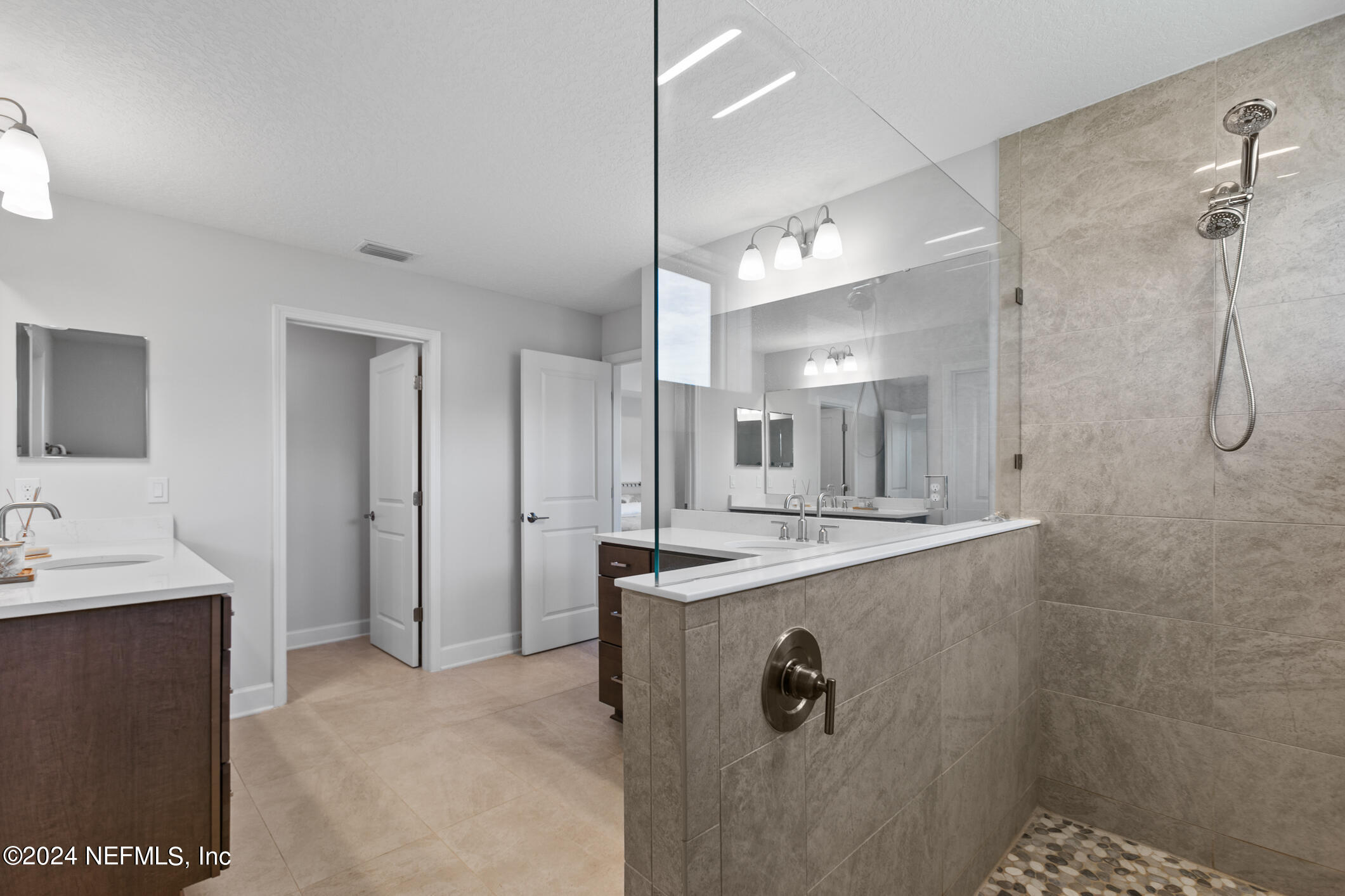 10020 Invention Lane Jacksonville, FL 32256 - Photo 40 of 87 a bathroom with a granite countertop sink a mirror and shower