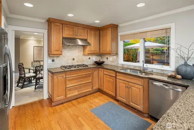 a kitchen with stainless steel appliances granite countertop a sink stove and cabinets