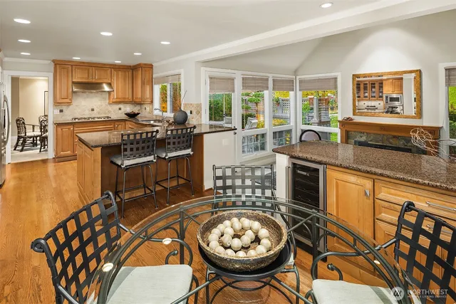 a kitchen with stainless steel appliances granite countertop a stove a sink a refrigerator and wooden cabinets