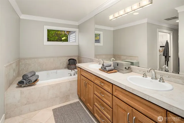 a bathroom with a tub double sink and mirror