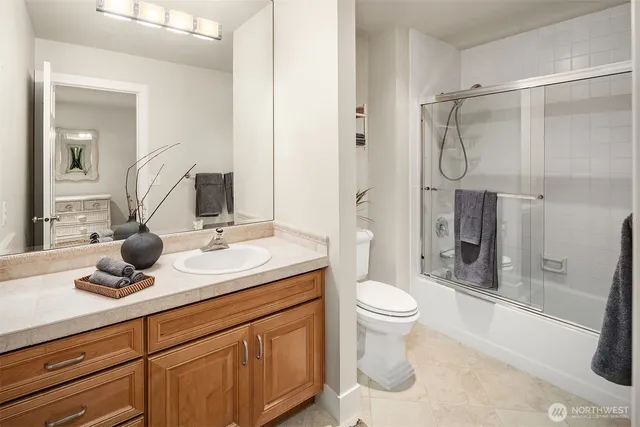 a bathroom with a shower sink vanity mirror and toilet