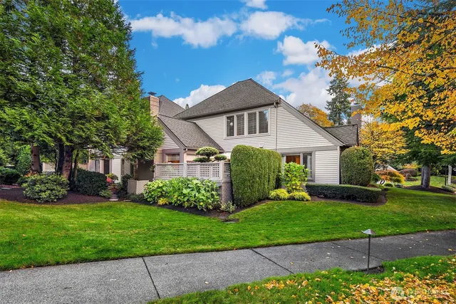 a front view of a house with a garden and trees