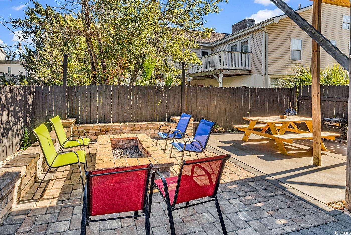 124 B Vista Drive Murrells Inlet, SC 29576 - Photo 35 of 38 Fenced backyard with a fire pit, outdoor dining space, and a patio area