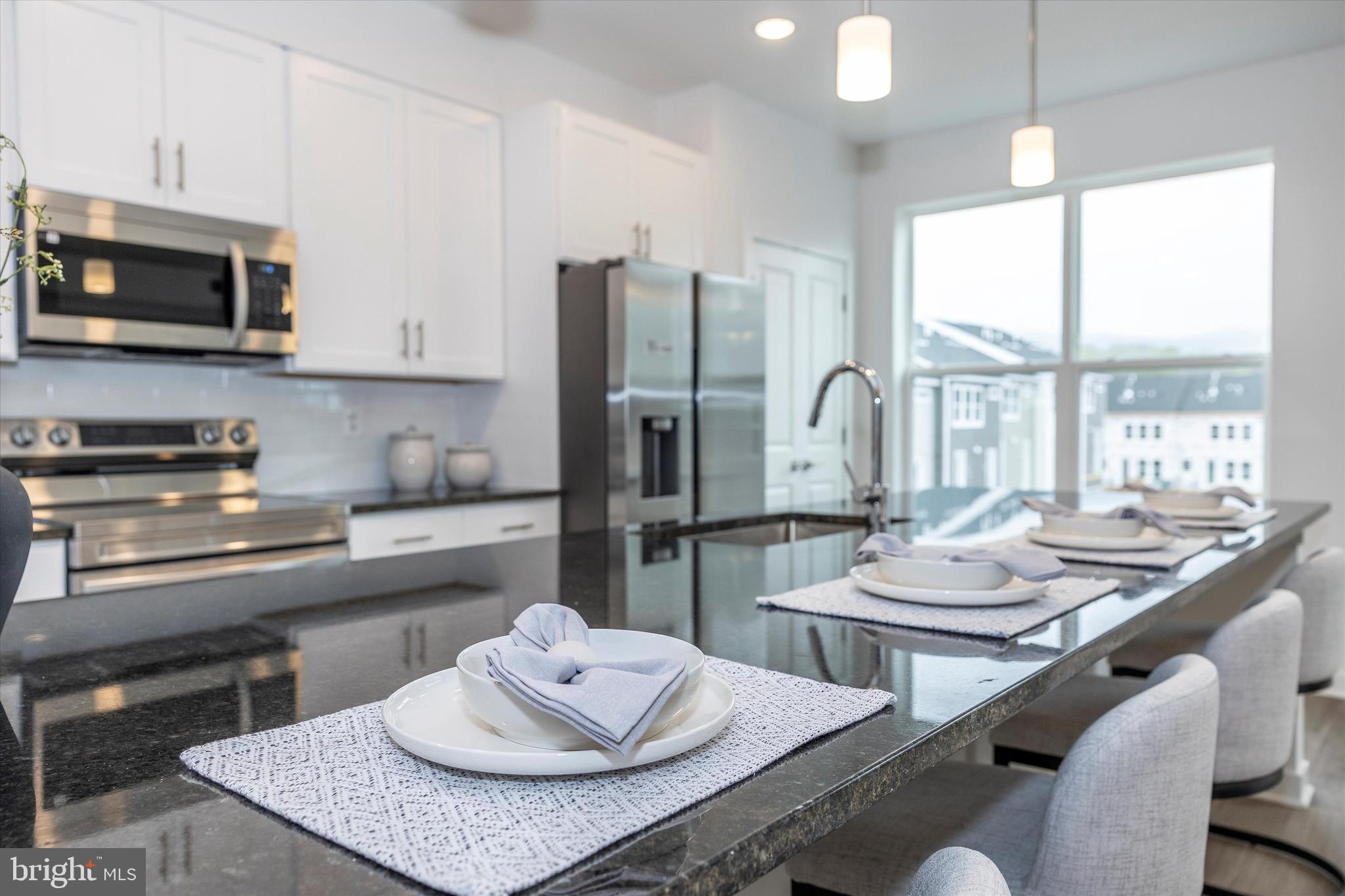 709 B Iron Frg Road Frederick, MD 21702 - Photo 9 of 32 a kitchen with stainless steel appliances kitchen island granite countertop a stove a sink a dining table and chairs