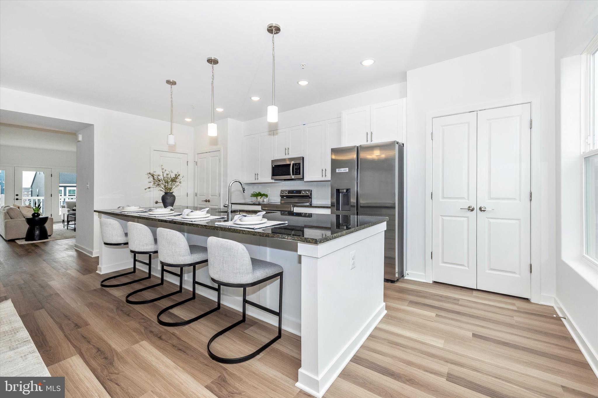 709 B Iron Frg Road Frederick, MD 21702 - Photo 10 of 32 a kitchen with stainless steel appliances kitchen island granite countertop a refrigerator a stove a sink a dining table and chairs with wooden floor
