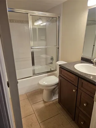 an empty room with a chandelier fan and windows