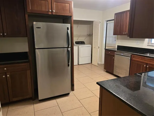 a kitchen with stainless steel appliances granite countertop a refrigerator a stove and a sink