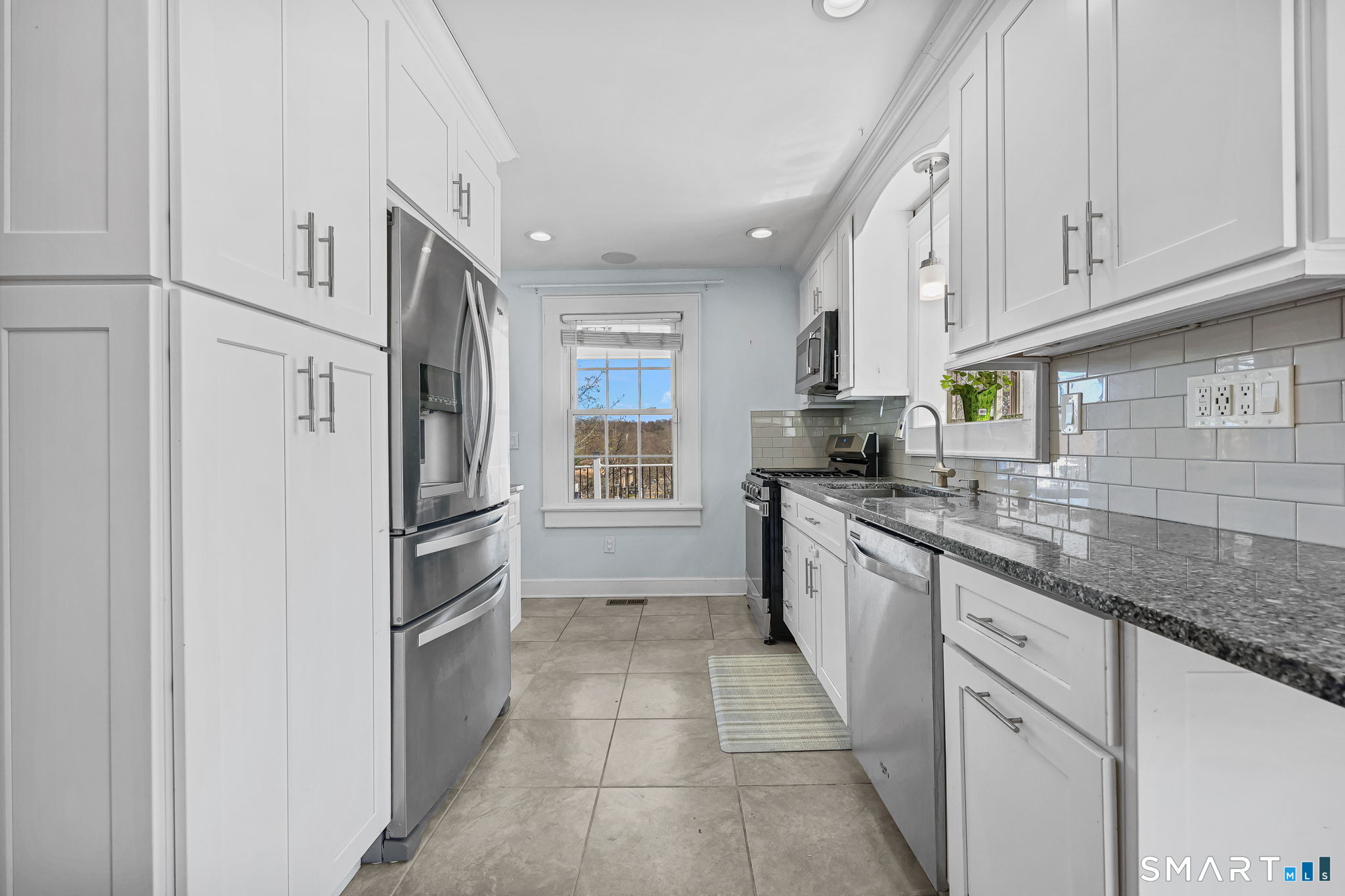 105 Knickerbocker Avenue Stamford, CT 06907 - Photo 11 of 31 a kitchen with white cabinets and white appliances