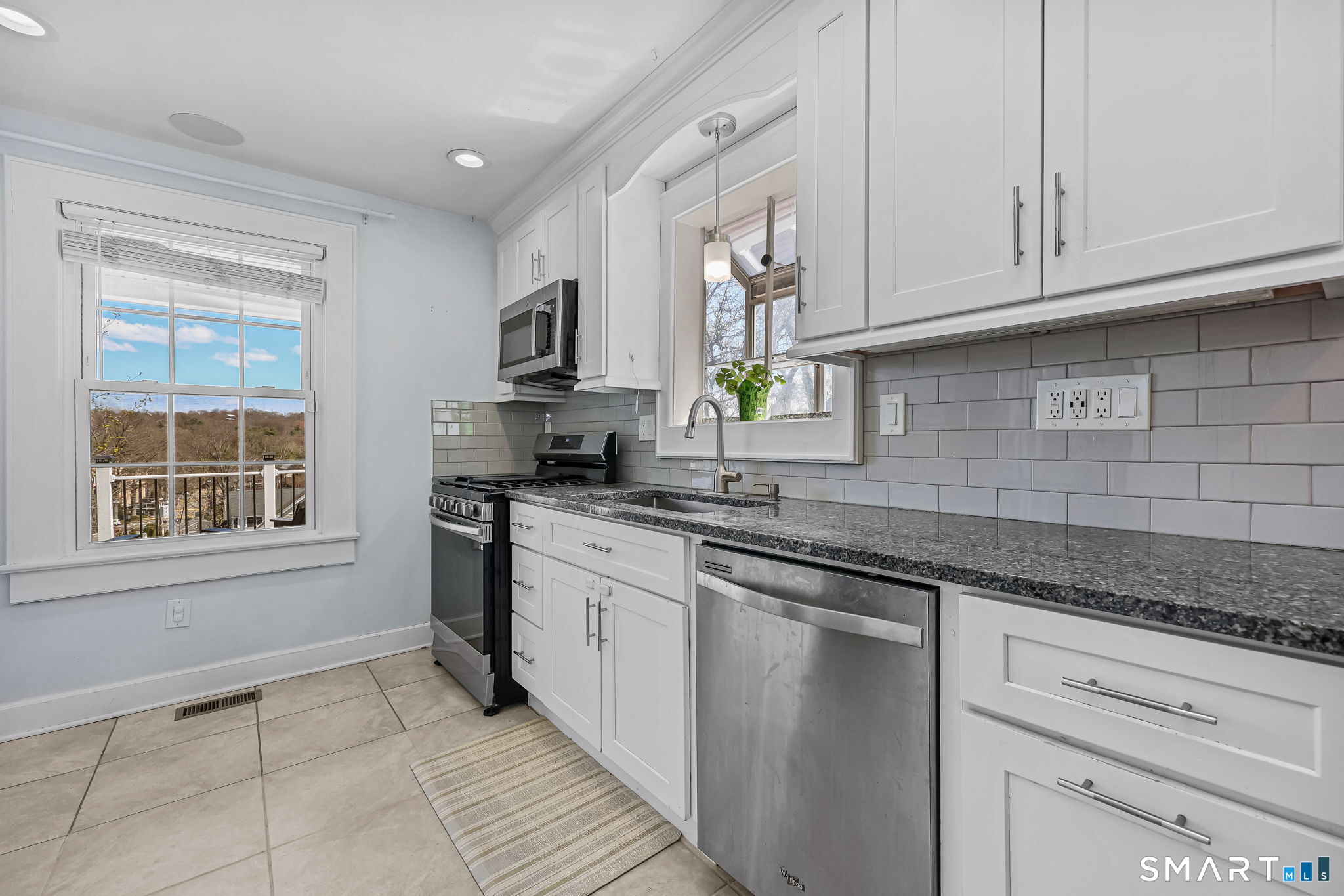 105 Knickerbocker Avenue Stamford, CT 06907 - Photo 12 of 31 a kitchen with granite countertop white cabinets stainless steel appliances a sink and a window