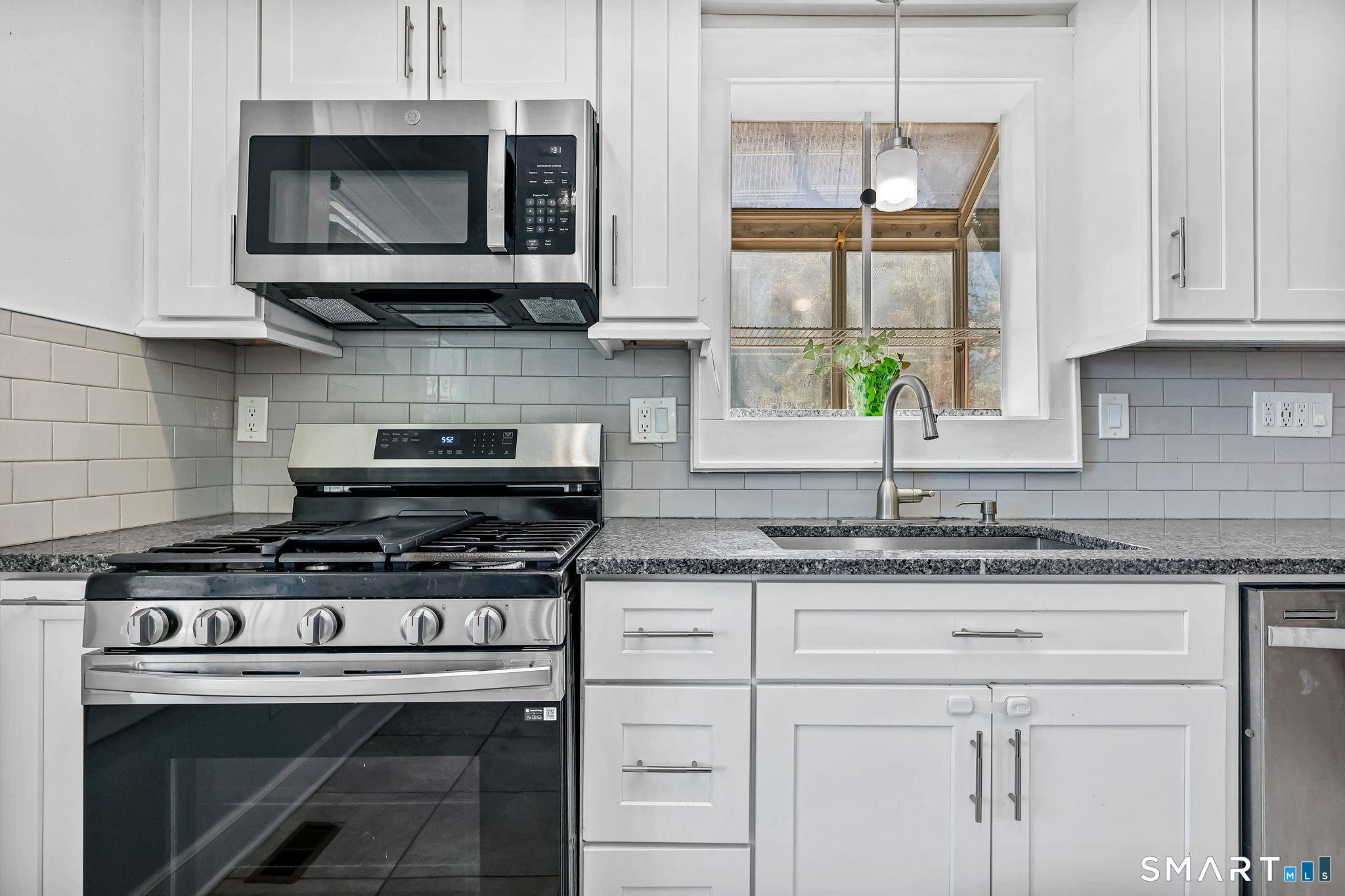105 Knickerbocker Avenue Stamford, CT 06907 - Photo 14 of 31 a kitchen with stainless steel appliances granite countertop white cabinets and a stove top oven