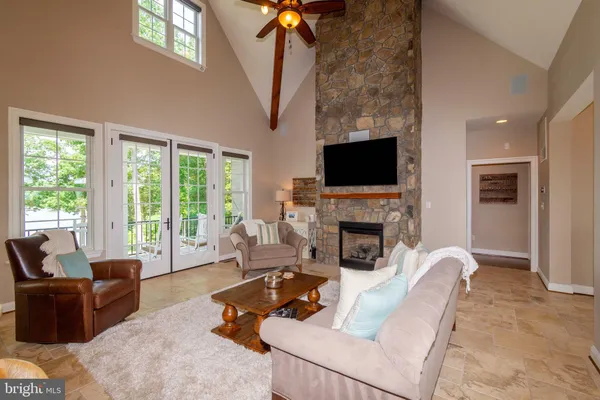 a kitchen with a stove a sink a kitchen island with chairs and wooden floor