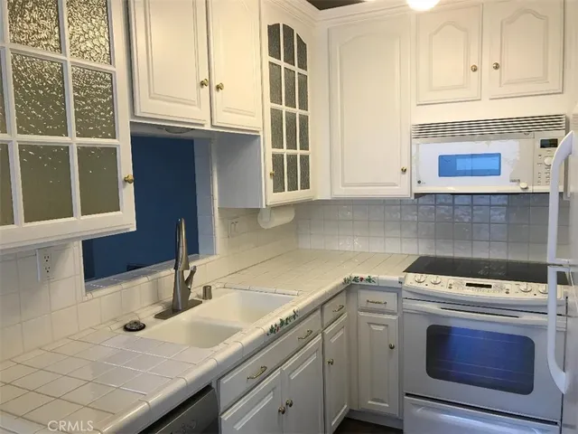 a kitchen with stainless steel appliances granite countertop a sink and a microwave