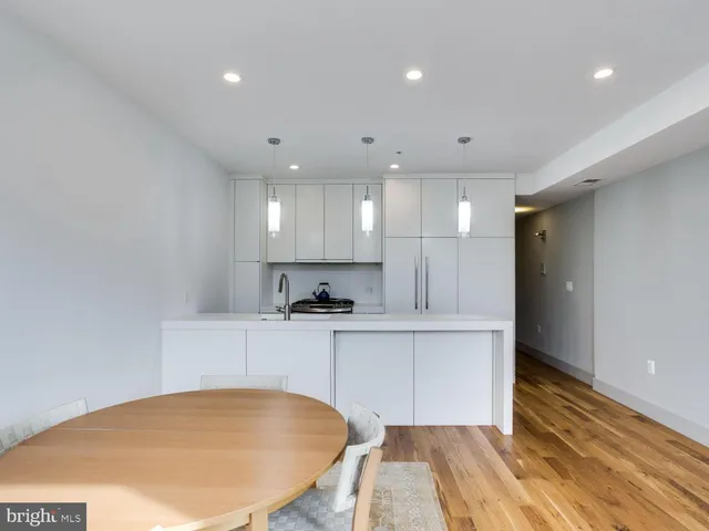 a large white kitchen with wooden floors