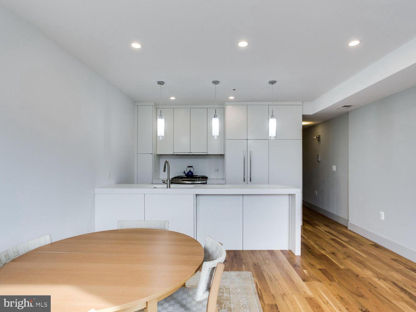 254 15th Street Southeast, Unit 4 Washington, DC 20003 - Photo 9 of 23 a large white kitchen with wooden floors