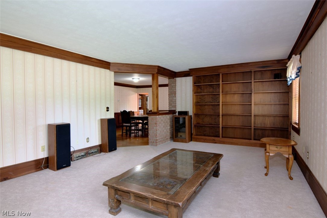 7251 Ryan Road Medina, OH 44256 - Photo 5 of 47 Living area featuring light-toned carpeting, extensive wood-finish built-in shelving, and wood-finish trim