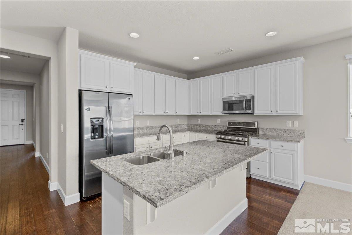 10098 Ignacio Circle Reno, NV 89521 - Photo 12 of 40 a kitchen with stainless steel appliances granite countertop a sink refrigerator and microwave