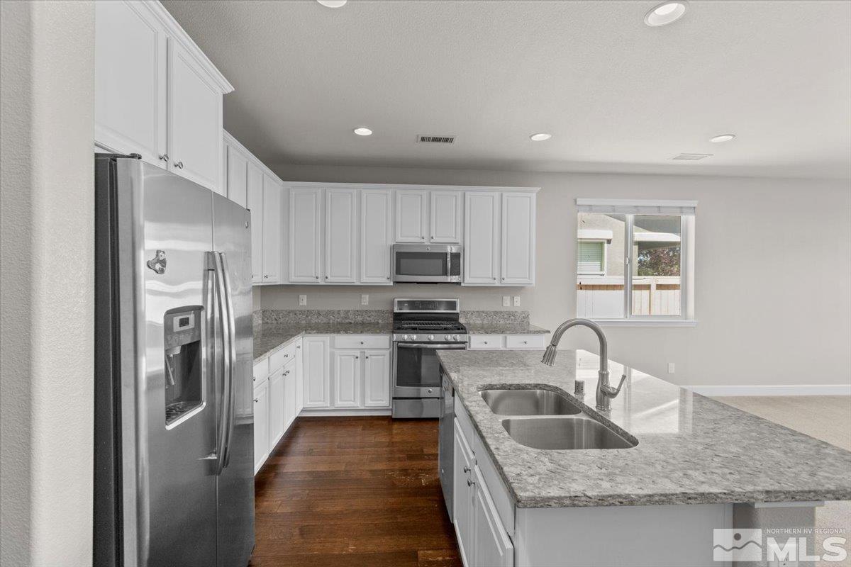 10098 Ignacio Circle Reno, NV 89521 - Photo 13 of 40 a kitchen with stainless steel appliances granite countertop a refrigerator sink and stove