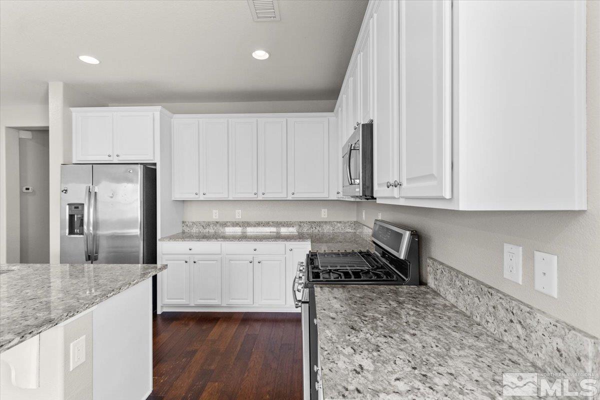 10098 Ignacio Circle Reno, NV 89521 - Photo 14 of 40 a kitchen with granite countertop a stove a sink and a refrigerator