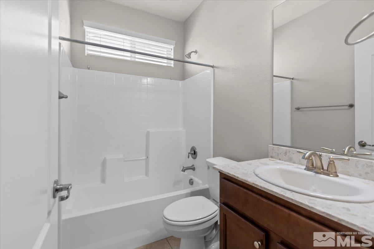 10098 Ignacio Circle Reno, NV 89521 - Photo 19 of 40 a bathroom with a granite countertop sink toilet and shower