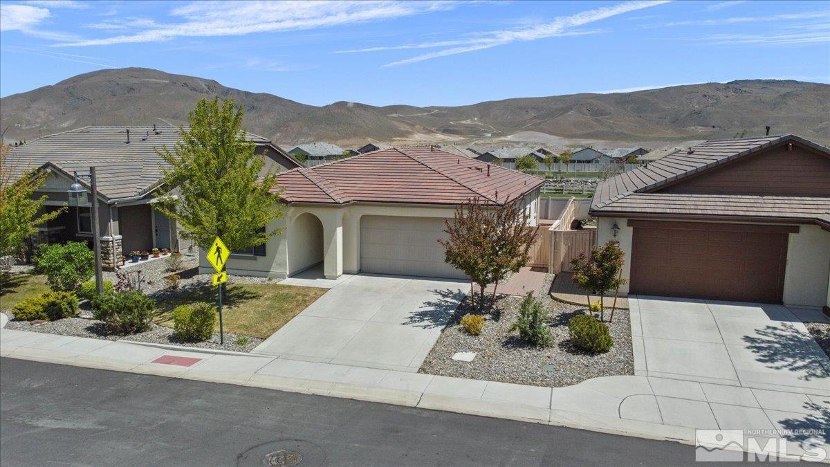 10098 Ignacio Circle Reno, NV 89521 - Photo 3 of 40 a front view of a house with a garden and mountain view