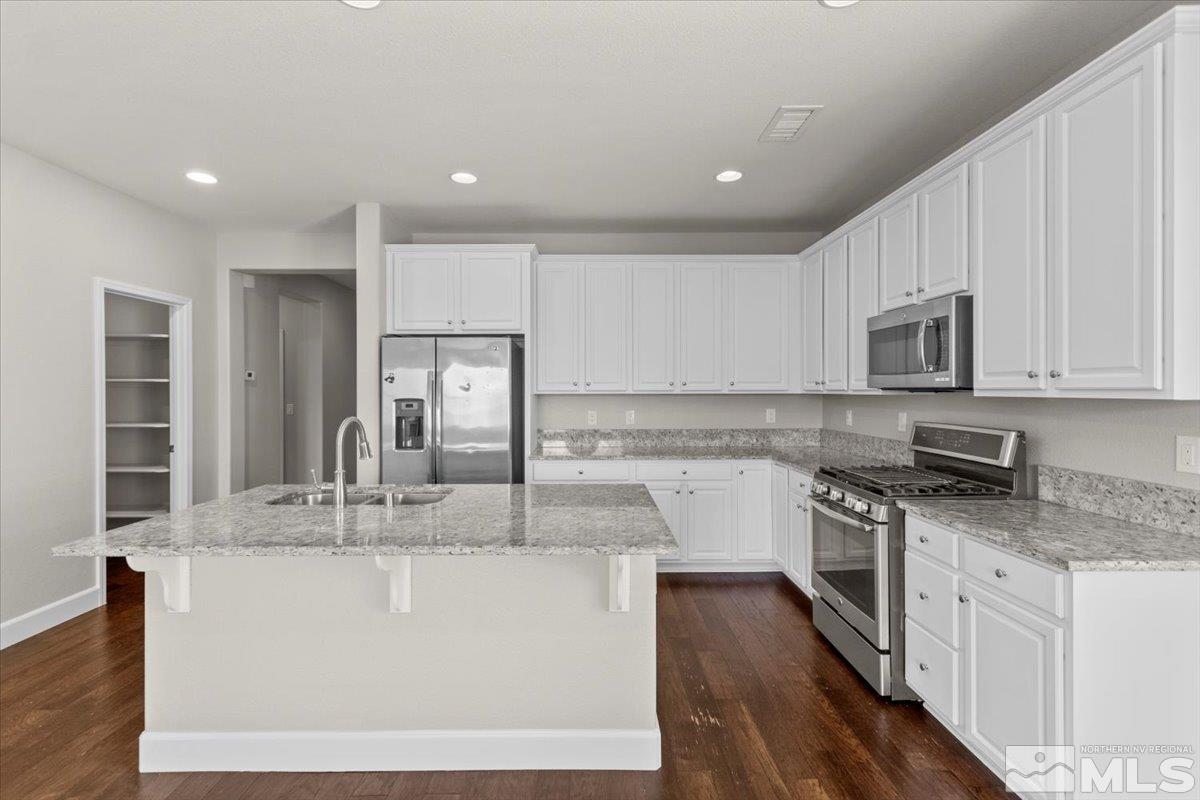 10098 Ignacio Circle Reno, NV 89521 - Photo 10 of 40 a kitchen with stainless steel appliances granite countertop a sink a stove a microwave and island