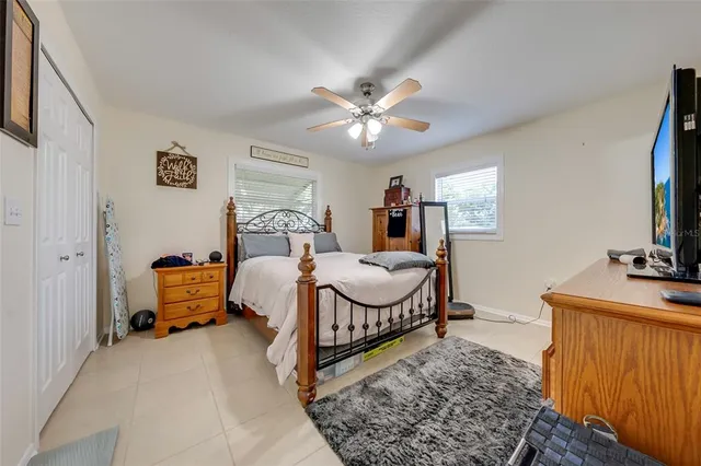 a bedroom with a bed and a flat tv screen on the dresser