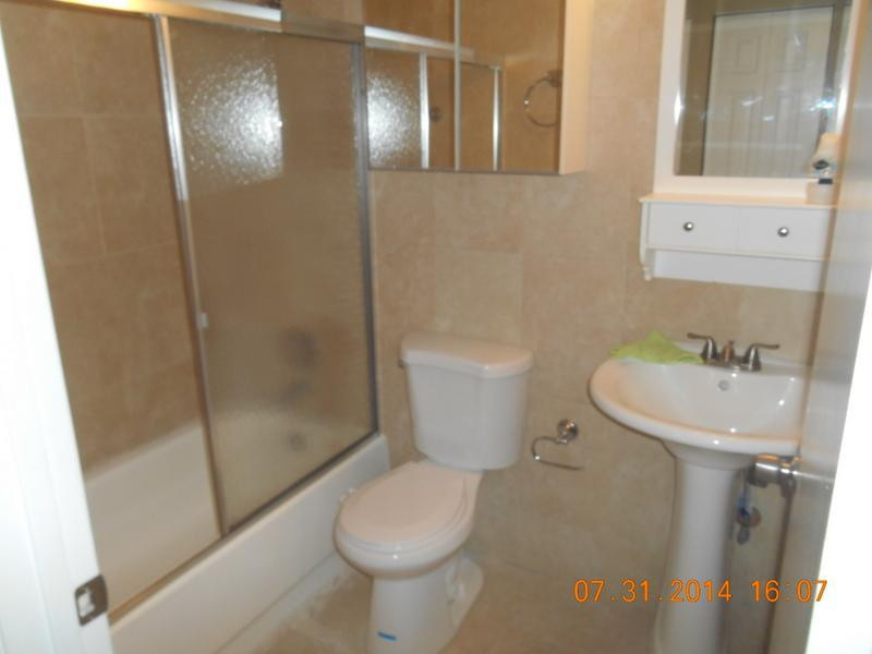 926 Falling Water Road Weston, FL 33326 - Photo 20 of 24 a white toilet sitting next to a bathroom sink