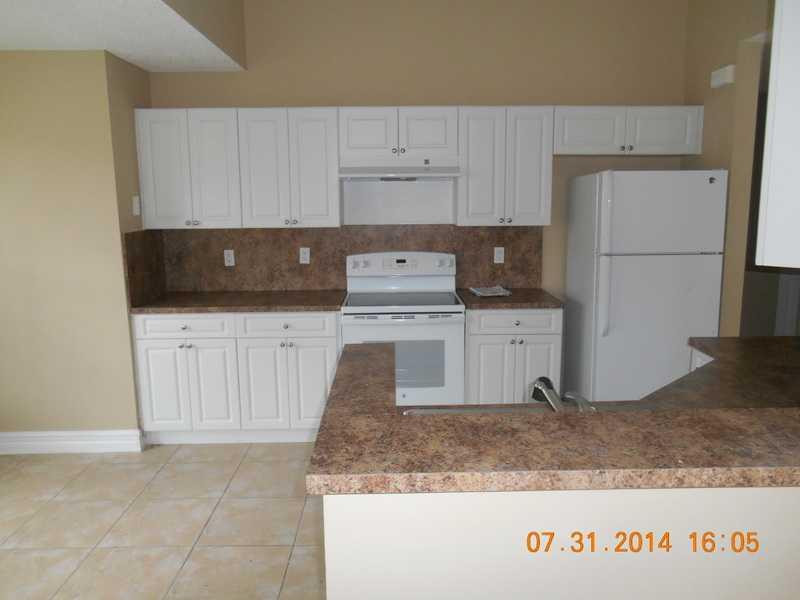 926 Falling Water Road Weston, FL 33326 - Photo 7 of 24 a kitchen with granite countertop a sink a stove and a refrigerator