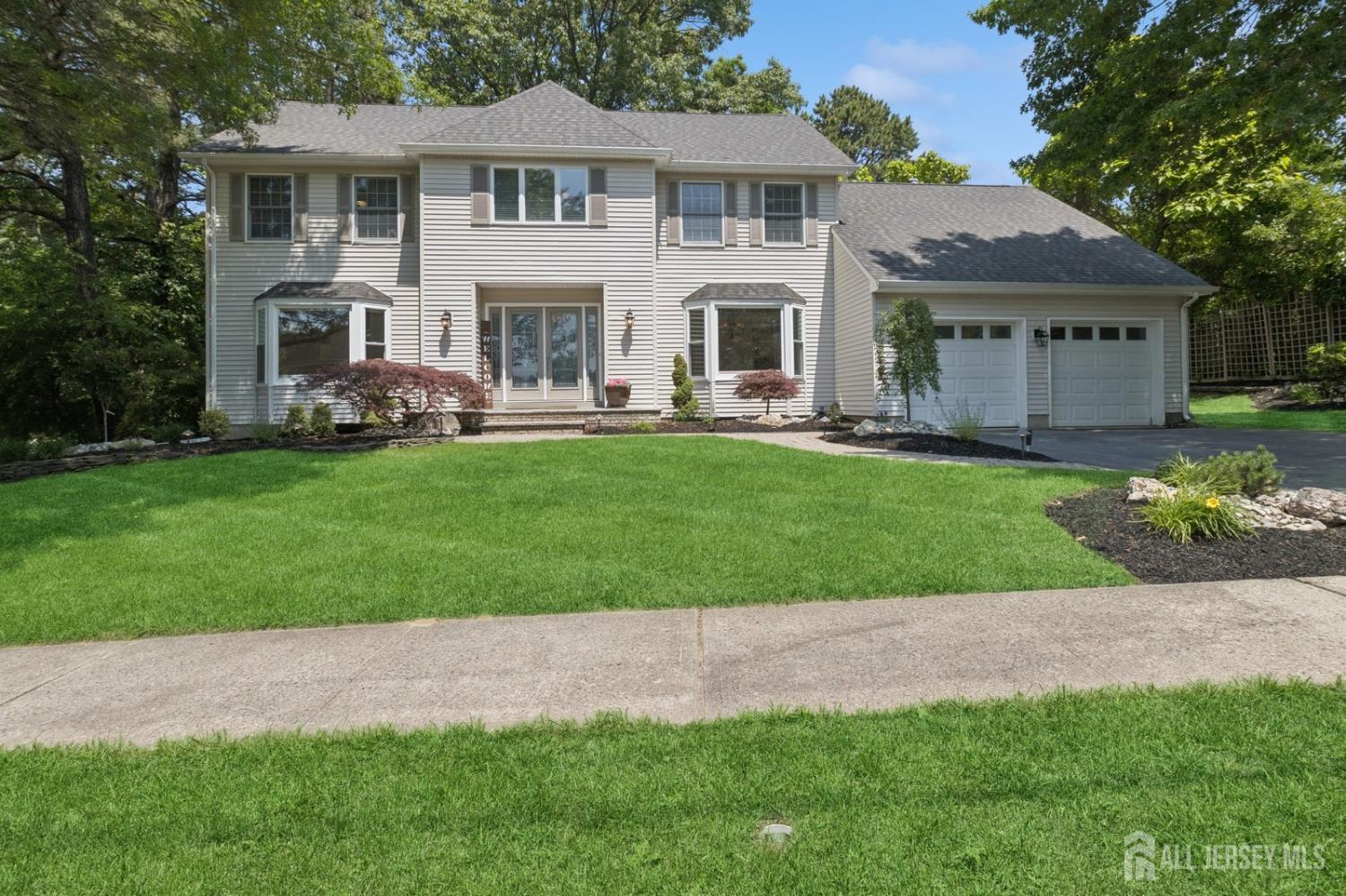 a front view of a house with a garden and plants