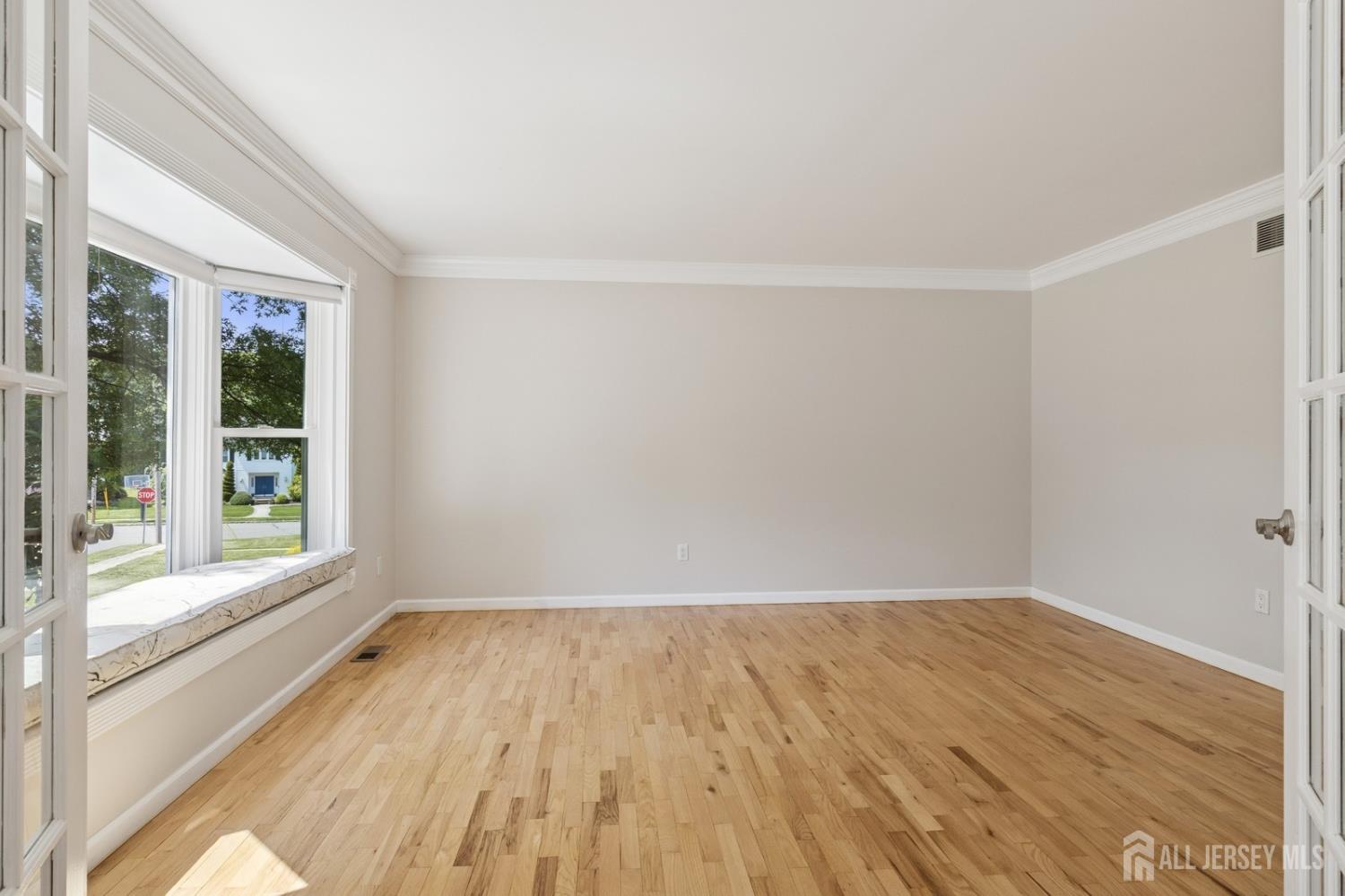 3 Cedar Lane Milltown, NJ 08850 - Photo 21 of 67 a view of an empty room with wooden floor and a window