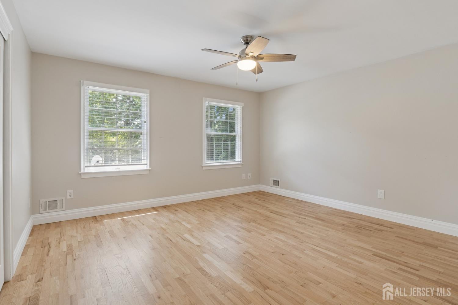 3 Cedar Lane Milltown, NJ 08850 - Photo 41 of 67 a view of an empty room with wooden floor and a window