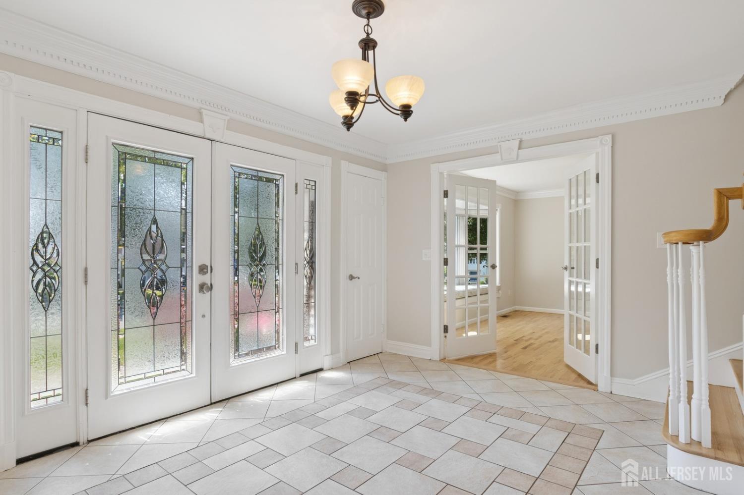 3 Cedar Lane Milltown, NJ 08850 - Photo 6 of 67 a view of a hallway with wooden floor and a chandelier