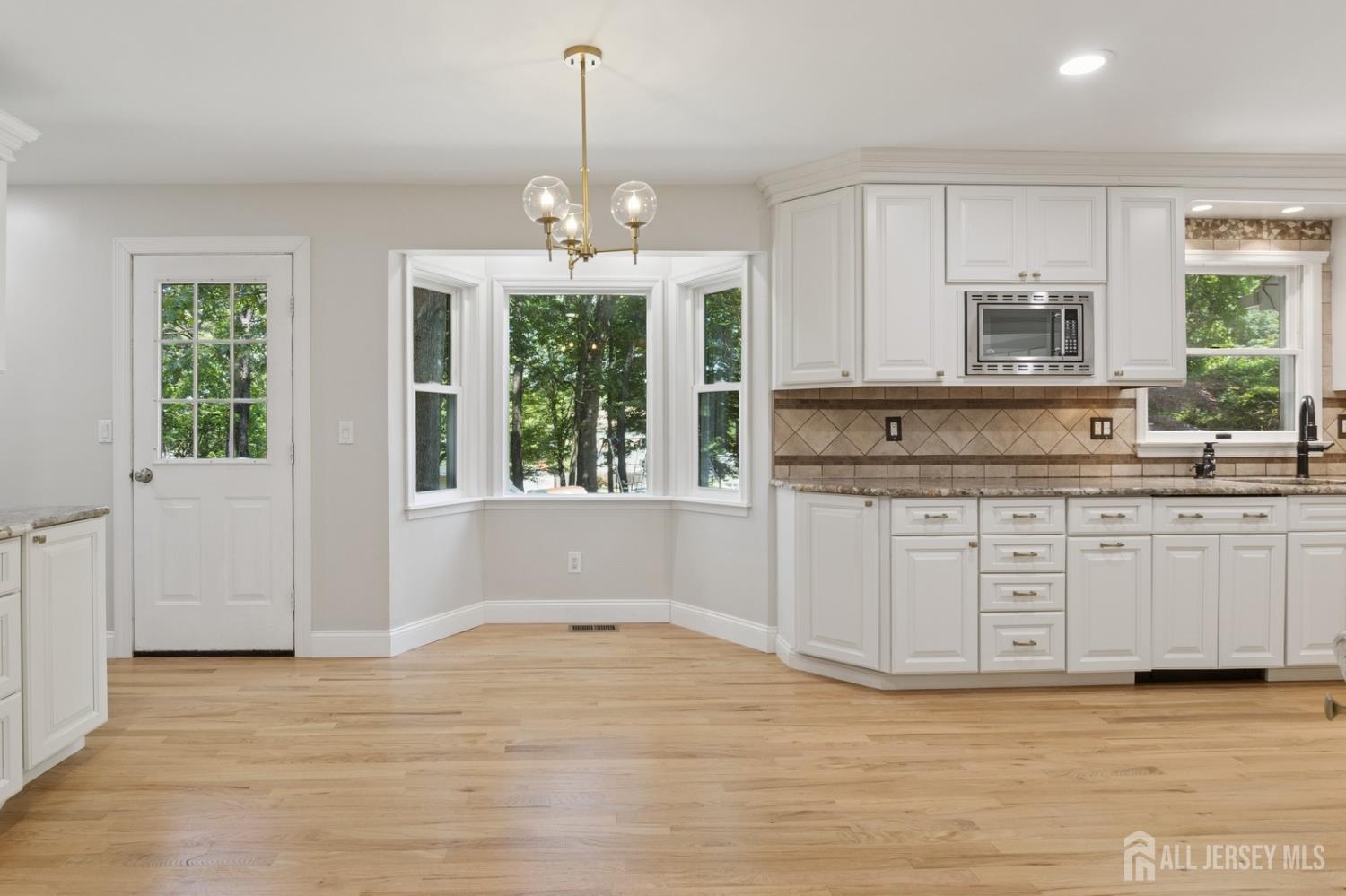 3 Cedar Lane Milltown, NJ 08850 - Photo 10 of 67 a kitchen with stainless steel appliances granite countertop a stove a sink and white cabinets with wooden floor