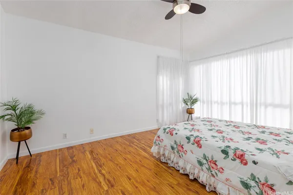 a bedroom with a bed and a potted plant