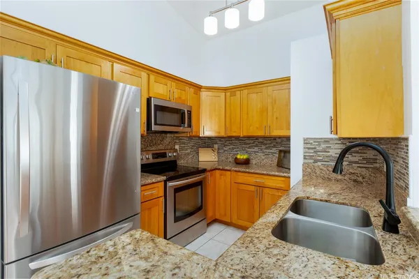 a kitchen with granite countertop a sink stainless steel appliances and cabinets
