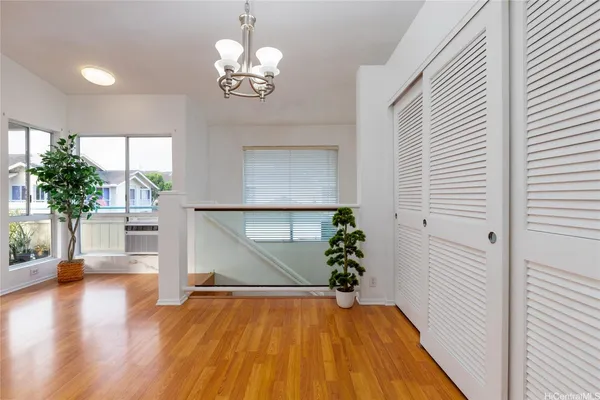 a view of a room with wooden floor potted plant and a chandelier
