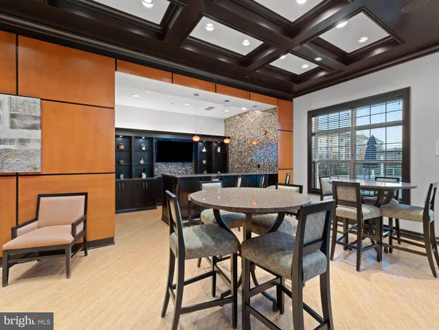 a living room with stainless steel appliances granite countertop couches a flat screen tv and kitchen view