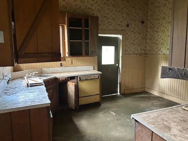 a view of kitchen with granite countertop sink and stove