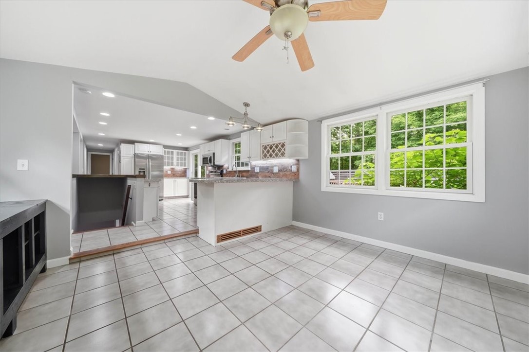 214 Anan Wade Road Glocester, RI 02857 - Photo 17 of 50 The kitchen continues into a large, light-filled dining room, surrounded by windows with peaceful views of the wooded setting
