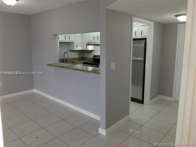 4160 Inverrary Drive, Unit 505 Lauderhill, FL 33319 - Photo 7 of 16 a living room with stainless steel appliances granite countertop a refrigerator and a sink