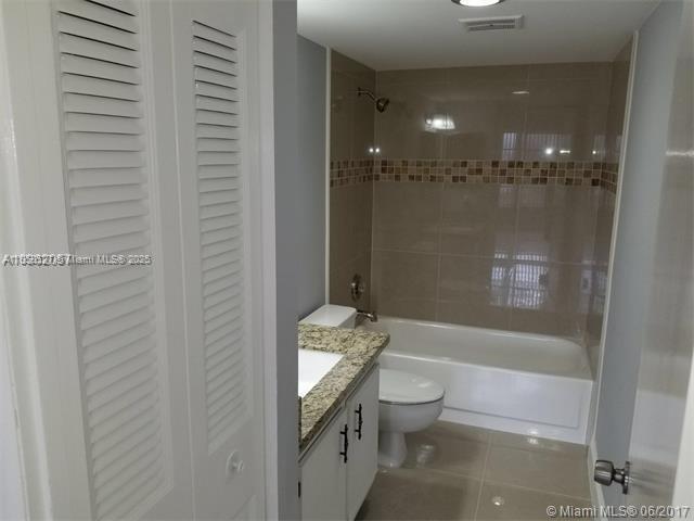 4160 Inverrary Drive, Unit 505 Lauderhill, FL 33319 - Photo 10 of 16 a bathroom with a granite countertop sink a toilet and shower