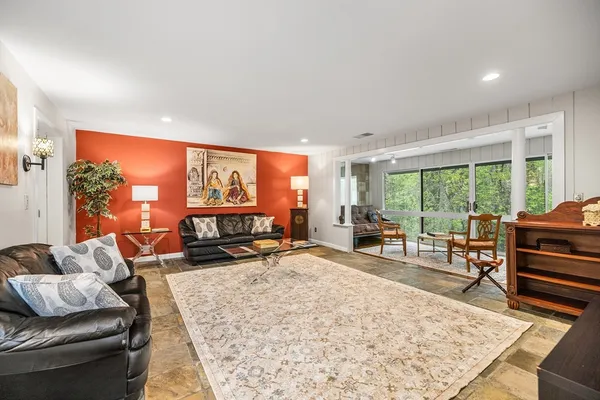 a living room with furniture a rug and a large window