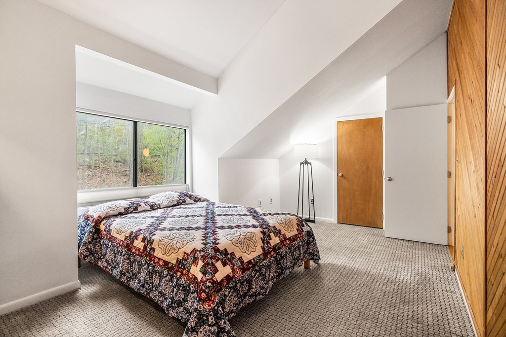 370 Great Road, Unit 8 Acton, MA 01720 - Photo 19 of 27 a bedroom with a bed lamp and a large window