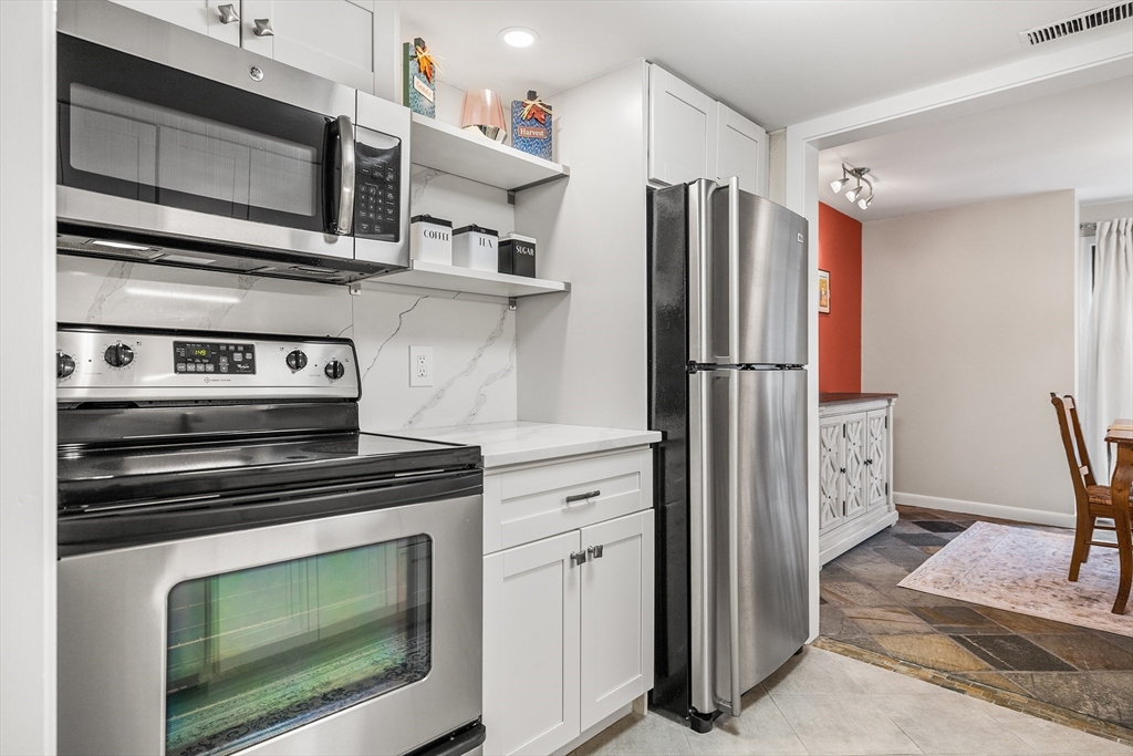 370 Great Road, Unit 8 Acton, MA 01720 - Photo 9 of 27 a kitchen with stainless steel appliances wooden cabinets and stove top oven