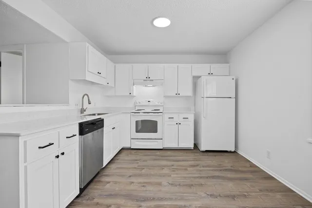 a kitchen with white cabinets and white appliances