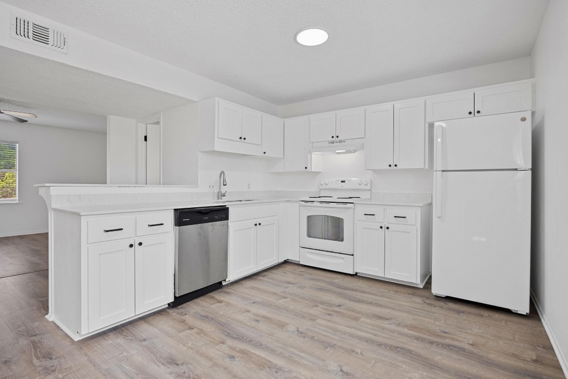 5211 Thunderbird Street, Unit A Lago Vista, TX 78645 - Photo 14 of 26 a kitchen with cabinets stainless steel appliances and wooden floor
