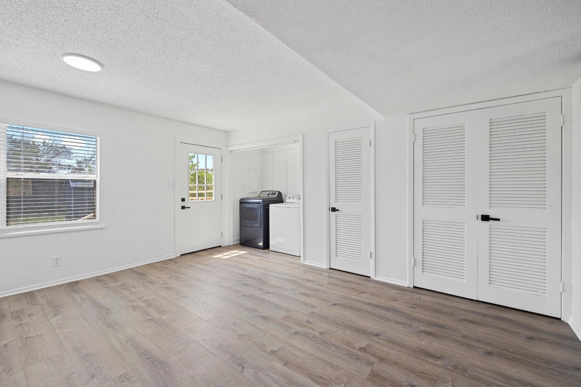5211 Thunderbird Street, Unit A Lago Vista, TX 78645 - Photo 15 of 26 a view of an empty room with wooden floor and a window