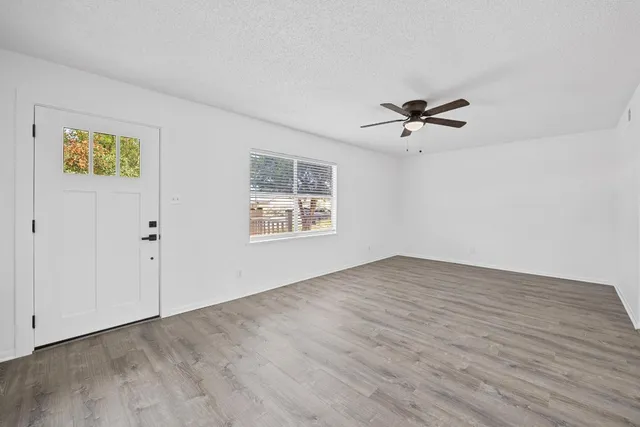 an empty room with fan and windows
