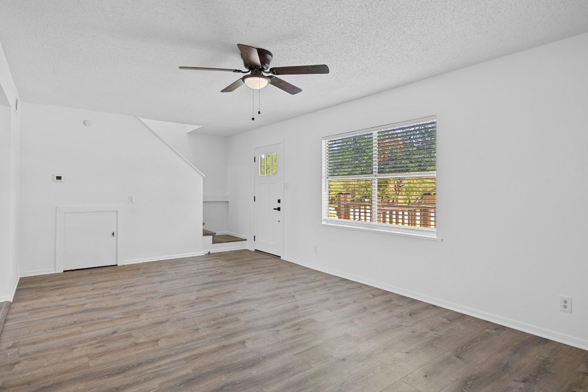 5211 Thunderbird Street, Unit A Lago Vista, TX 78645 - Photo 9 of 26 a view of empty room with wooden floor and fan